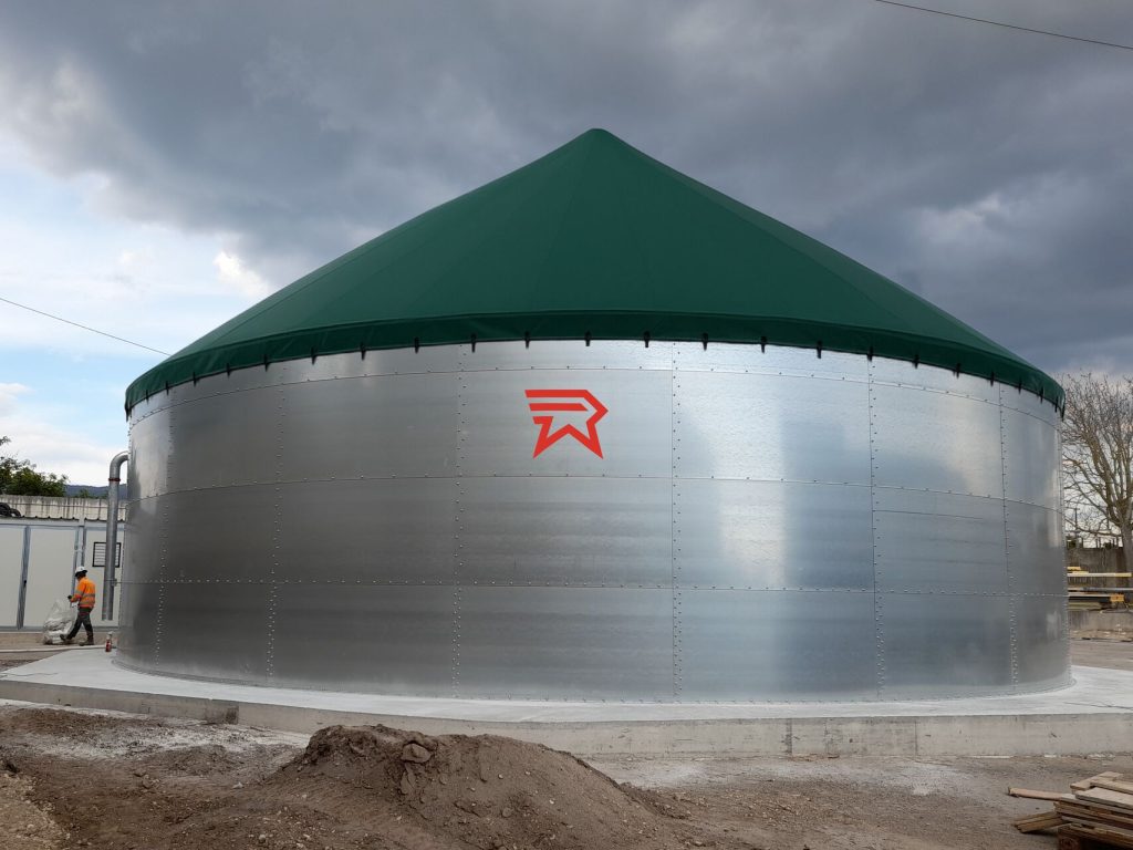 Serbatoio agricolo in acciaio con tetto verde conico e logo rosso.